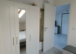 Cette chambre blanche comprend un lit et un miroir. dans l'établissement Casa Vacanza Alessia, à Silvi Marina