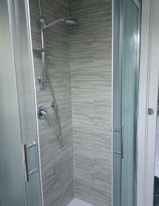 La salle de bains est pourvue d'une douche avec une porte en verre. dans l'établissement Casa Vacanza Alessia, à Silvi Marina