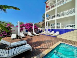 um resort com piscina e cadeiras e um edifício em Casa Do Mar Guest House em Praia do Tofo
