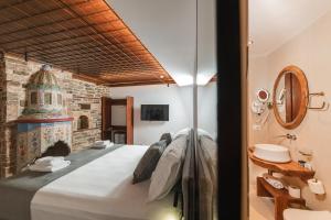 ein Schlafzimmer mit einem großen Bett und einer Ziegelwand in der Unterkunft DAM Stone Boutique Hotel in Gjirokastër