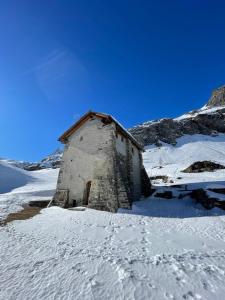 un pequeño edificio en la nieve con suelo cubierto de nieve en Le Village De Fours en Rhêmes-Notre-Dame