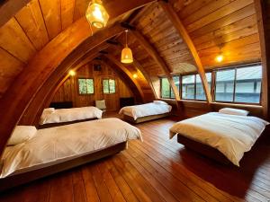 an attic bedroom with three beds in a room at Hakuba Mountain Cabin in Hakuba