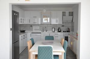 a kitchen with white cabinets and a table and chairs at Villa Mavi in Dalaman