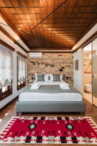 ein Schlafzimmer mit einem großen Bett und einem roten Teppich in der Unterkunft DAM Stone Boutique Hotel in Gjirokastër