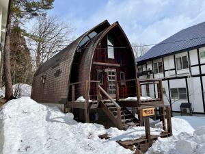 uma casa de cúpula na neve em frente a uma casa em Hakuba Mountain Cabin em Hakuba