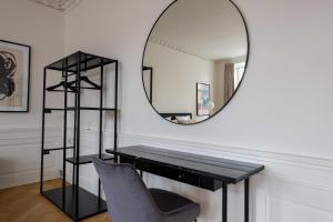 - un miroir dans une chambre avec un bureau et une chaise dans l'établissement Rare 4BR Apartment w Unique Details in CPH City, à Copenhague