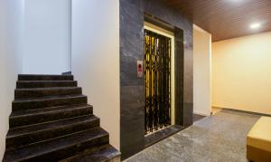 a staircase with a black wall and a door at Itsy By Treebo - Yogeshwara Grand in Shamshabad