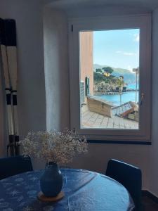 a table with a vase on a table with a window at Apartment Da Pupetta in Sori