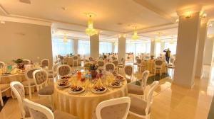 a banquet hall with white tables and white chairs at Amy in Oradea