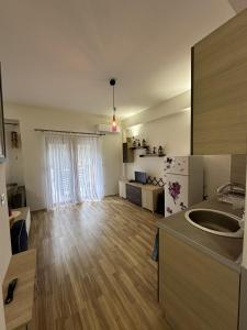 Forest View Apartment في مافروفو: غرفة معيشة مع مطبخ مع أرضية خشبية