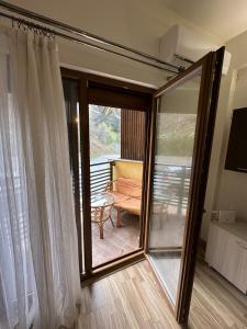 Forest View Apartment في مافروفو: غرفة مع باب زجاجي منزلق مع شرفة