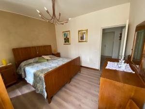 een slaapkamer met een bed en een houten vloer bij La Corte Di Ottorina in Pederobba