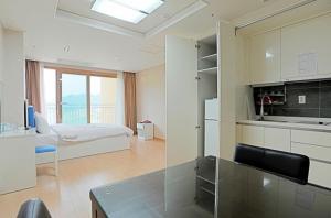 a room with a kitchen and a bedroom with a bed at High Castle Resort in Jeongseon