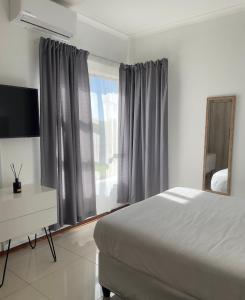 een slaapkamer met een bed, een bureau en een raam bij Grey Net in Palatswe