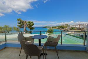 een balkon met een tafel en stoelen en een tennisbaan bij Hotel Esmerald Ksamil in Ksamil