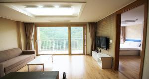 High Castle Resort في جونغ سون: غرفة معيشة بها أريكة وتلفزيون