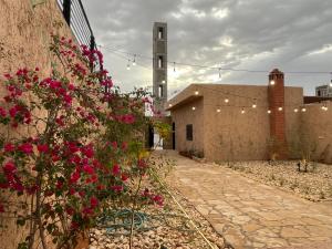 a courtyard with pink flowers and a building at شاليهات حائط طيني in Riyadh