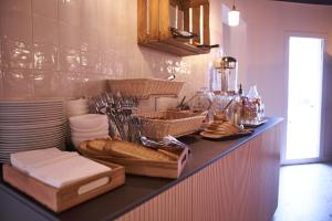 a kitchen with a counter with bread and plates at Théo Hôtel Limoges, The Originals City in Limoges