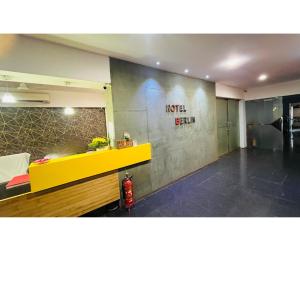 a room with a yellow counter and a wall with writing on it at The Berlin in Gandhinagar