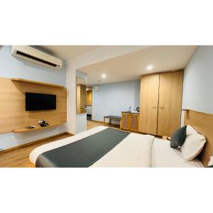 a bedroom with a bed and a flat screen tv at The Berlin in Gandhinagar