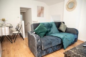 a leather couch in a living room with a table at Corporate-Friendly 2BR Apartment in Leeds, Near Kirkstall Shopping Centre in Leeds
