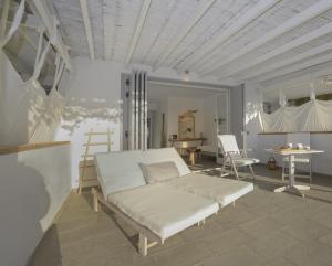 a white bed in a room with a table at Olivemare in Katelios