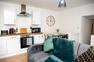 een woonkamer met een bank en een keuken bij Corporate-Friendly 2BR Apartment in Leeds, Near Kirkstall Shopping Centre in Leeds