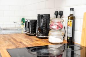 a kitchen counter with a counter top with a jar of food at Corporate-Friendly 2BR Apartment in Leeds, Near Kirkstall Shopping Centre in Leeds