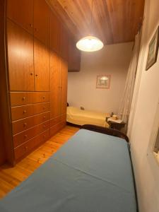 a bedroom with a bed and wooden cabinets at ΙΩΑΝΝΑ in Dhirrévmata
