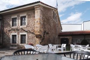 un groupe de tables et de chaises devant un bâtiment dans l'établissement Posada la Estela de Barros, à Los Corrales de Buelna