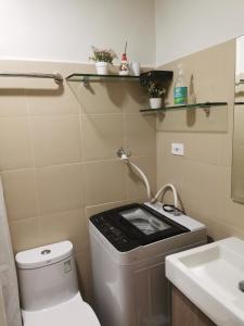 a small bathroom with a toilet and a sink at Shore 3 mall of Asia condotel in Manila
