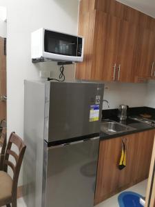 a small kitchen with a microwave and a refrigerator at Shore 3 mall of Asia condotel in Manila