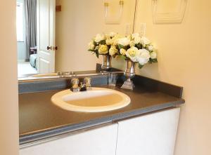 a bathroom sink with a vase of flowers on it at Harmony House in Richmond
