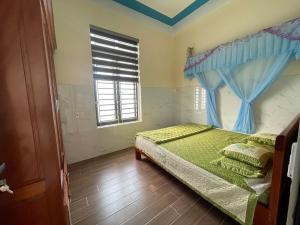 Schlafzimmer mit einem Bett und einem Fenster in der Unterkunft Homestay Sea View Ông Hoành 