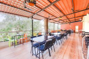 a dining room with tables and chairs on a balcony at FabHotel The Horizon I in Lonavala