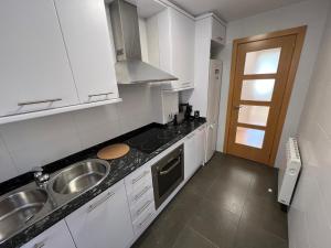 a kitchen with white cabinets and a sink at Apartament reformat al Berguedà in Sant Jordi de Cercs