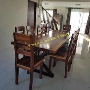 a wooden dining room table with wooden chairs and a table at Pinsuk house Huahin บ้านปิ่นสุข หัวหิน ชะอำ in Phetchaburi