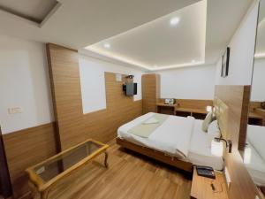 Staynest darjeeling near railway station في دارجيلنغ: غرفة نوم فيها سرير وتلفزيون