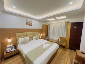 um quarto com uma grande cama branca num quarto em Staynest darjeeling near railway station em Darjeeling