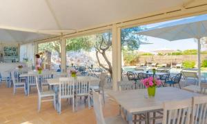 a restaurant with tables and chairs and a large window at Hotel Garden Salento in Torre Vado