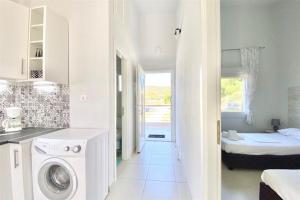 une cuisine blanche avec une machine à laver dans une pièce dans l'établissement Domniki's Sea House, à Asprovalta 13 autres photos