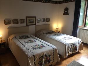 a bedroom with two beds and two lamps on the wall at Colle Rampo in Colleferro