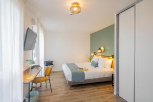 a bedroom with a bed and a desk with a computer at All Suites Appart Hôtel - Le Havre Centre - Les docks in Le Havre
