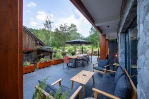 a patio with a table and chairs and an umbrella at Bransilvania Fantasy Boutique Chalet - Adults Only in Bran