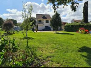 ein Haus in einem Garten mit grünem Rasen in der Unterkunft Amplia casa familiar in Pontevedra