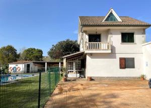 ein weißes Haus mit einem Zaun davor in der Unterkunft Amplia casa familiar in Pontevedra