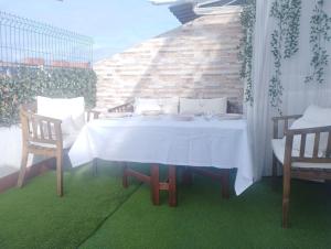 una mesa blanca con 2 sillas en el patio en Ático 4 personas con terraza amueblada y vistas. en Oviedo