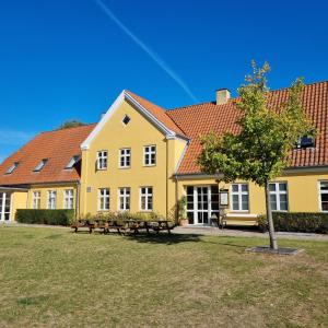 żółty budynek z ławkami przed nim w obiekcie Danhostel Ringsted w mieście Ringsted