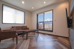 una sala de estar con un sofá y una mesa en 08 Resort Club -Theater-, en Fujikawaguchiko