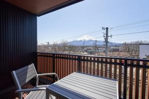 uma mesa e cadeira numa varanda com vista para uma montanha em 08 Resort Club -Theater- em Fujikawaguchiko